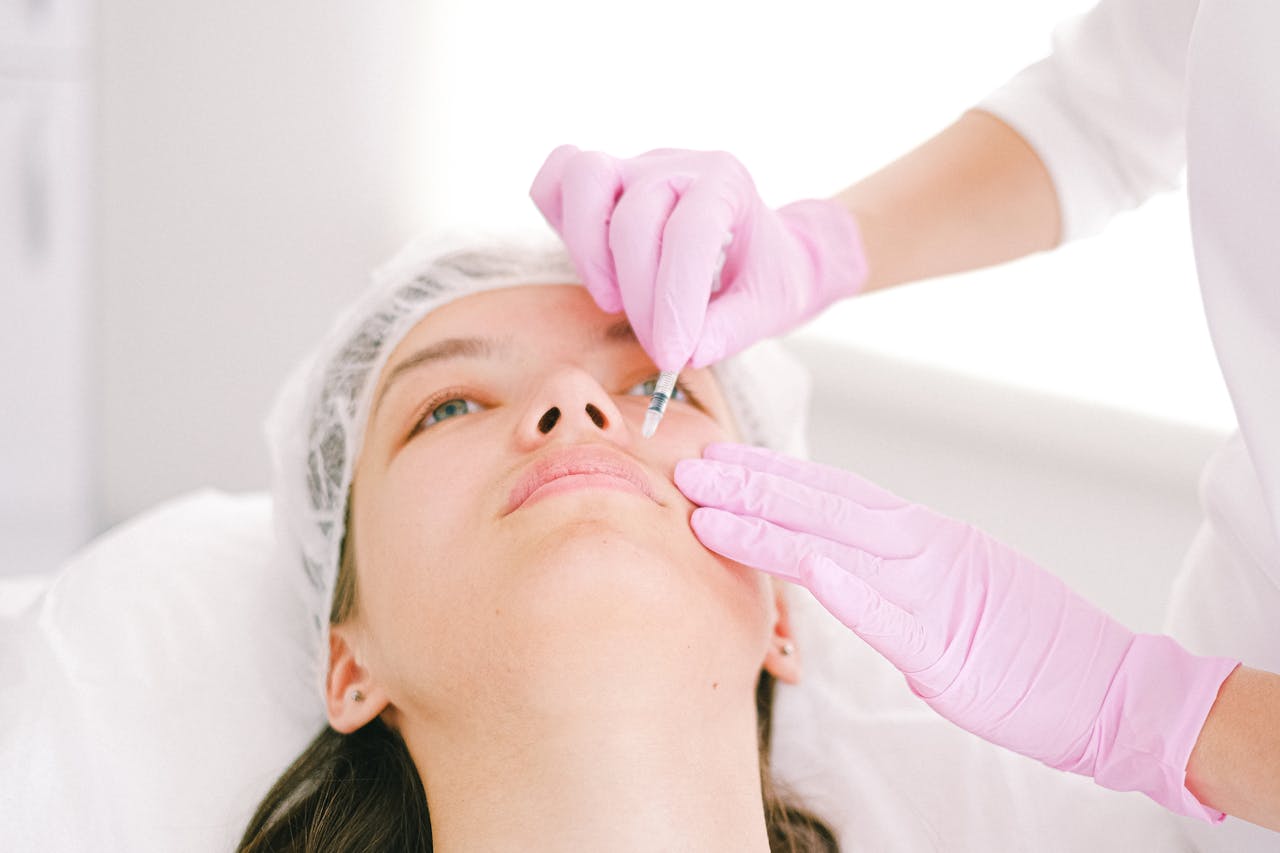 gallery-3 Woman receiving a facial cosmetic injection in a professional clinic setting.