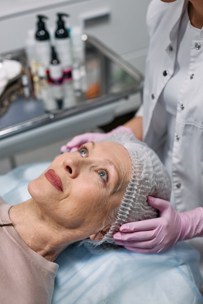 gallery-6 A senior woman undergoes a facial procedure at a medical clinic for rejuvenation.